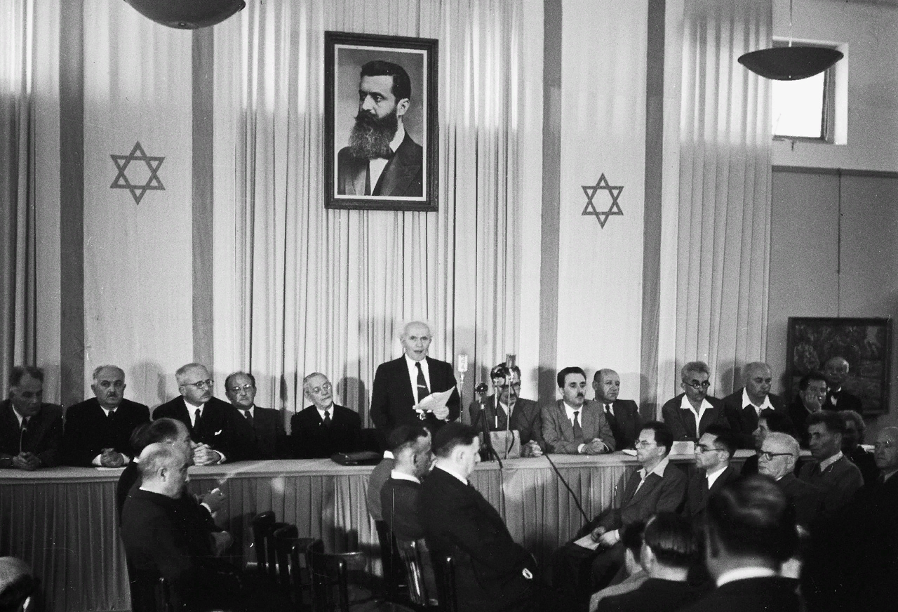 Давид Бен-Гурион провозглашает независимость Израиля под портретом Теодора Герцля